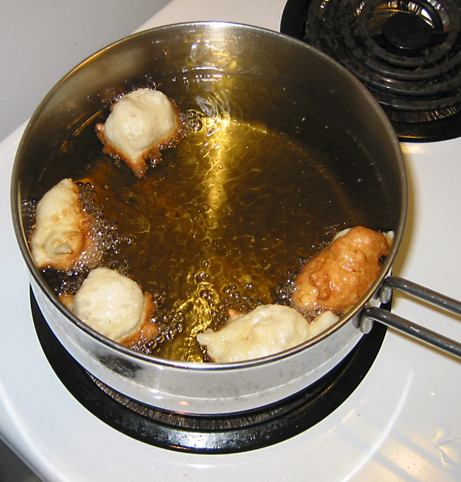 cooking apple fritters (portselkje) in hot oil